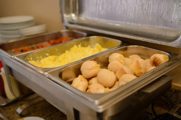 Ovos mexidos e pão de queijo no bufê quente