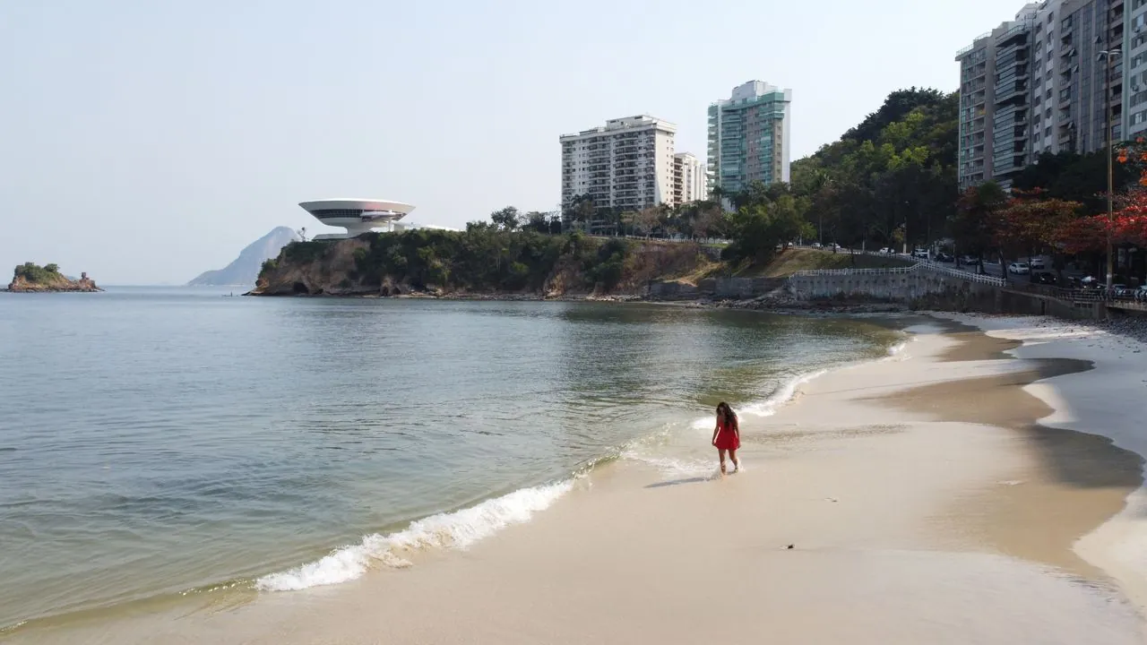Praia em Niterói com o MAC de Oscar Niemeyer no alto do costão
