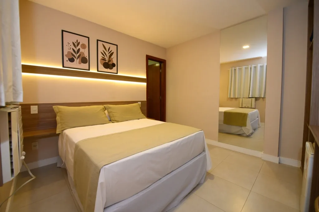Quarto Standard Casal com cama de casal, cabeceira iluminada, quadros botânicos e espelho de corpo inteiro