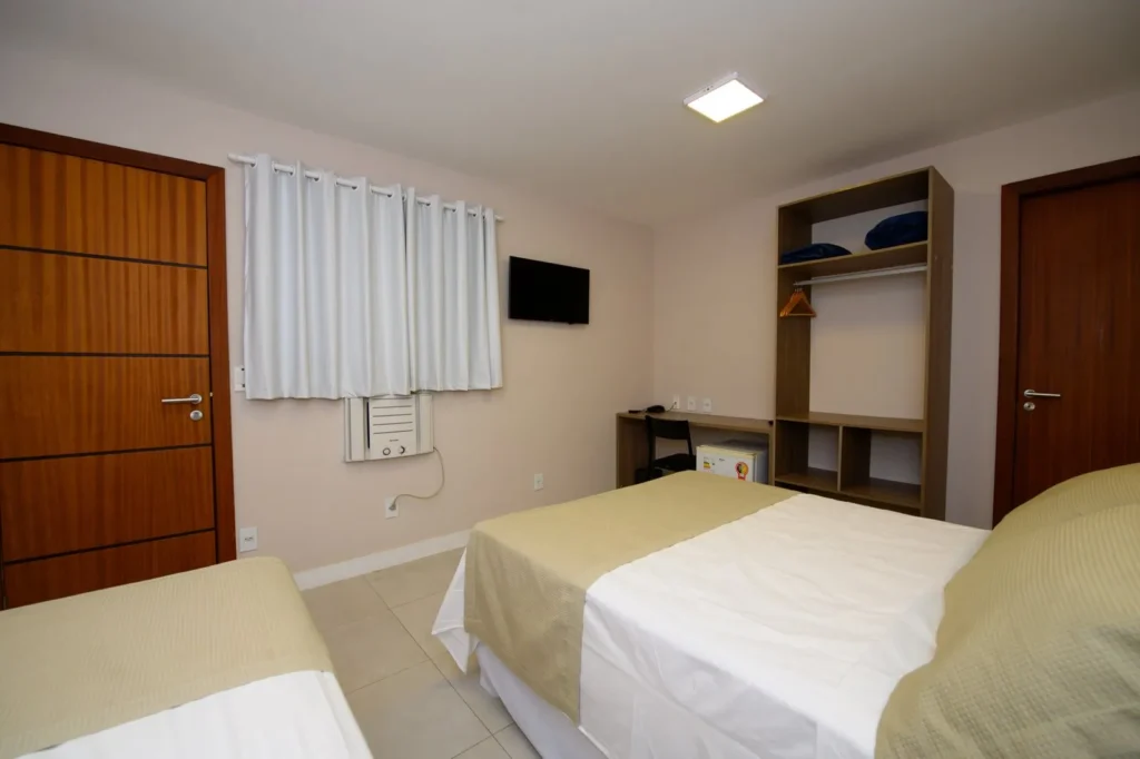 Quarto Standard Triplo com cama de casal e cama de solteiro, escrivaninha, frigobar, armário e TV