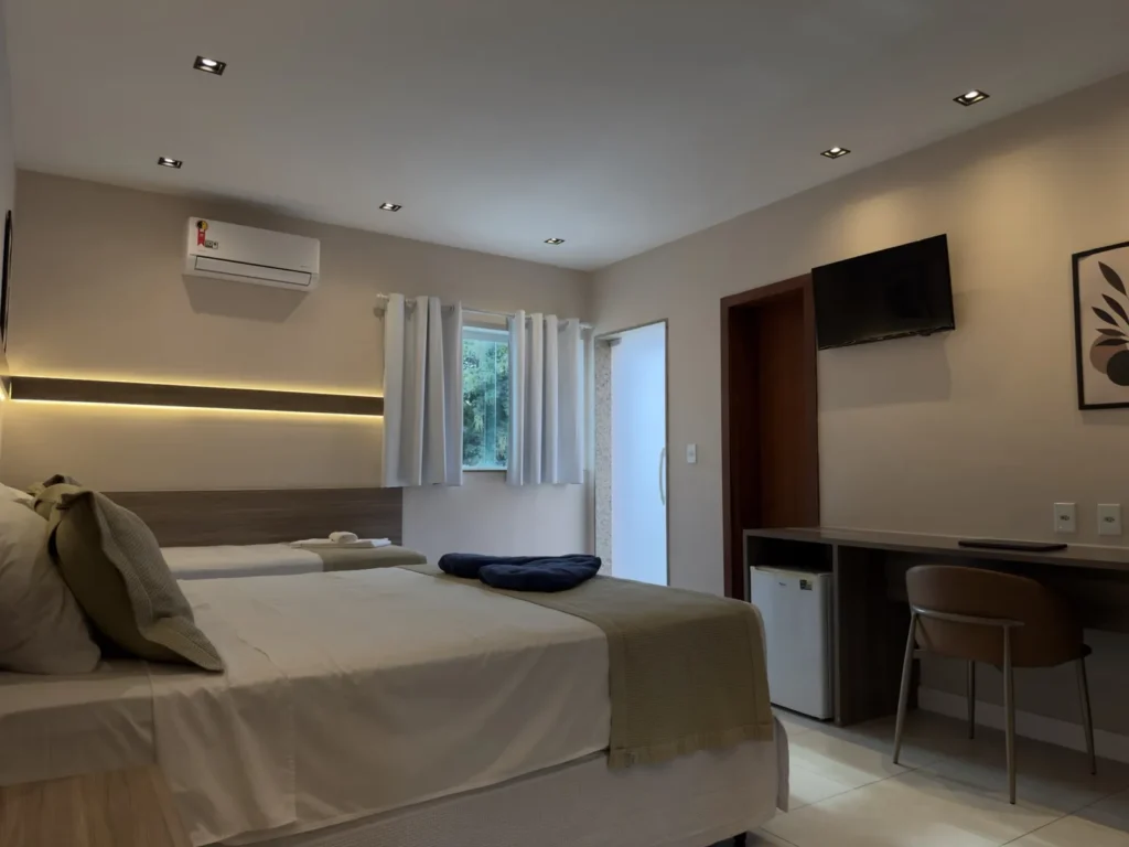 Quarto Superior Triplo claro com camas, ar split, escrivaninha e porta para a varanda